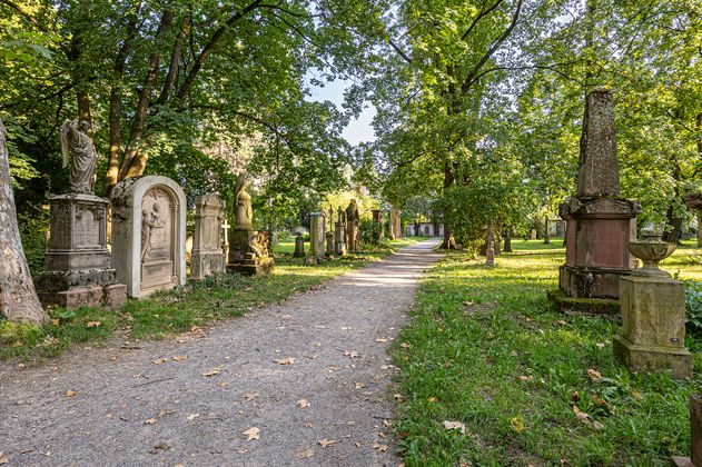 Ansicht des alten Friedhofes im Sommer mit einem Weg und verschiedenen Gräbern.
