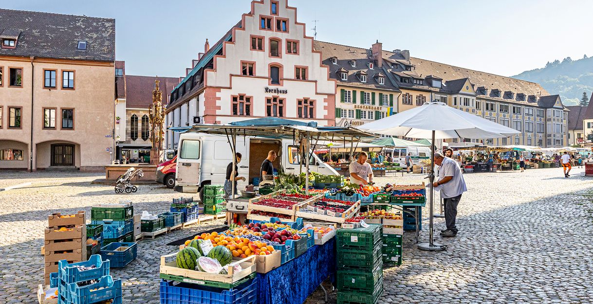 Stand auf dem Münstermarkt mit Obst und Gemüse und im Hintergrund das Kornhaus 