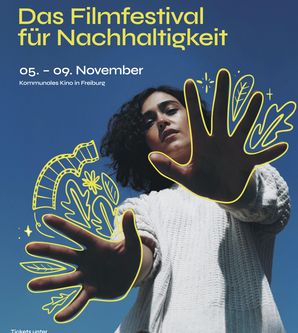 Das Poster des diesjährigen Festivals: Man sieht eine Person, die ihre Hände in Richtung Kamera streckt. Der Hintergrund ist blau. Darauf steht mit gelber Schrift: Das Filmfestival für Nachhaltigkeit. Fünfter bis neunter November. Kommunales Kino in Freiburg