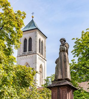 Turm der Martinskirche mit Bäumen davor 