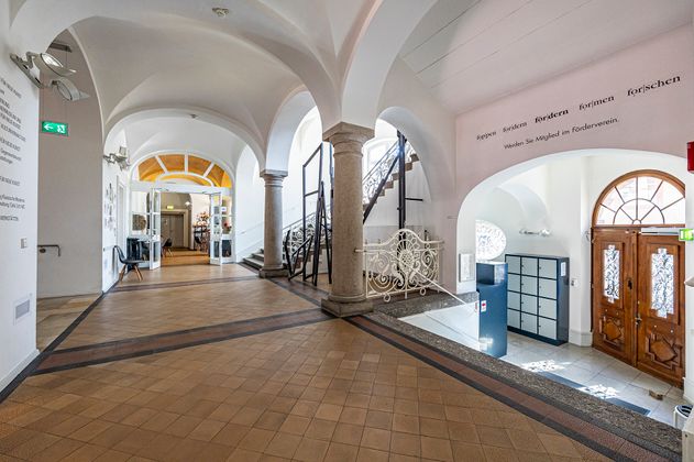 Flur mit Treppen und der Eingangstüre des Museums 