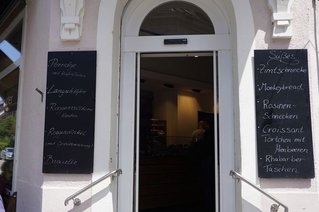 Eingang zu einer Bäckerei mit Speisekarten an den Seiten.