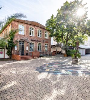 Vorderhaus von außen mit der Sonne am Himmel 