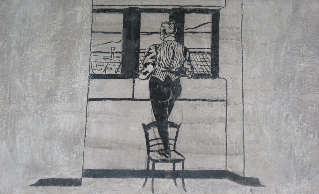 EIn Karzerinsasse blickt aus dem Fenster auf die Stadt Freiburg.