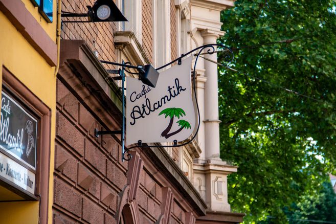 Schild des Café Atlantik an einer Hauswand in Freiburg.