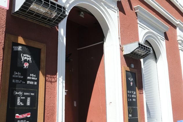 Eingang zur Cohibar mit roter Fassade und Werbetafeln.