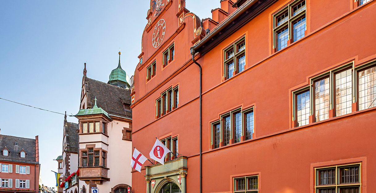 Rote Fassade des alten Rathauses mit Rheinkiesel-Mosaik 