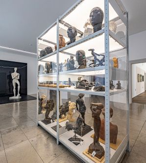 Glasvitrine in einem Ausstellungsraum mit verschiedenen Skulpturen 