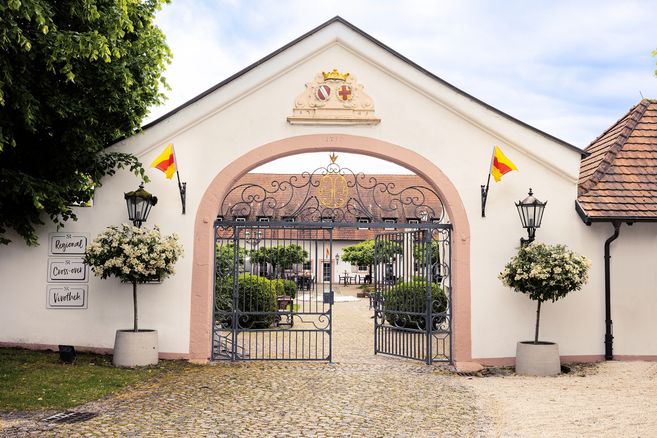 Blick auf das Tor des Hotel Schloss rReinach mit Blick in den Innenhof