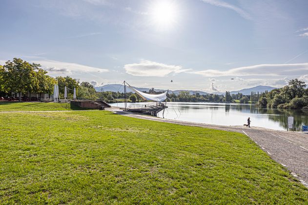 Liegewiese am See mit Restaurant im Hintergrund 
