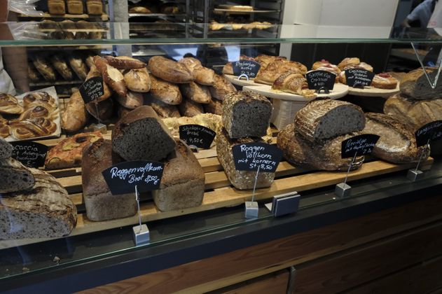 Verschiedene Brote und Backwaren in einer Bäckereiauslage.