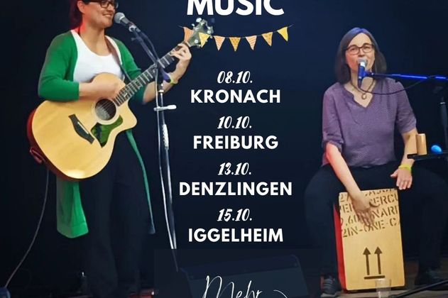 Es sind zwei fröhliche Musikerinnen auf einer Bühne zu sehen. Eine spielt Gitarre, die andere sitzt auf einer Cajon und trommelt. Es sind Ines Herrmann und Zannahh. In der Mitte des Bildes steht eine Überschrift, die mit einer kleinen Wimpelkette unterstrichen ist. Die Überschrift lautet "Live Music". Darunter stehen die vier Konzerttermine der beiden Künstlerinnen: 08.10. in Kronach, 10.10. in Freiburg, 13.10. in Denzlingen und 15.10. in Iggelheim. Mehr Informationen gibt es auf inesherrmann.eu/tour. Das steht ganz unten auf dem Bild mit drauf.