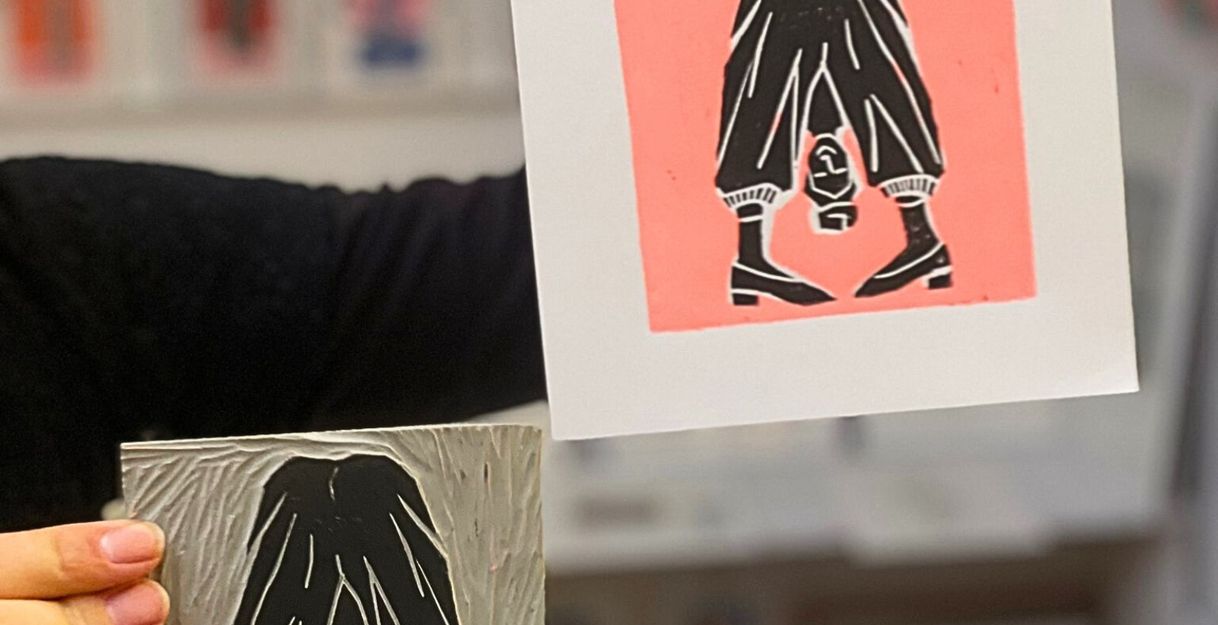 Ein im Workshop entstandener fertiger Linoldruck und die dazu gehörende Druckplatte werden in die Kamera gehalten