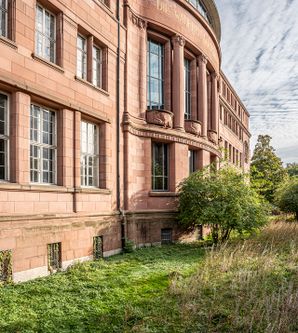Gebäude der Universität von außen mit roter Fassade. 