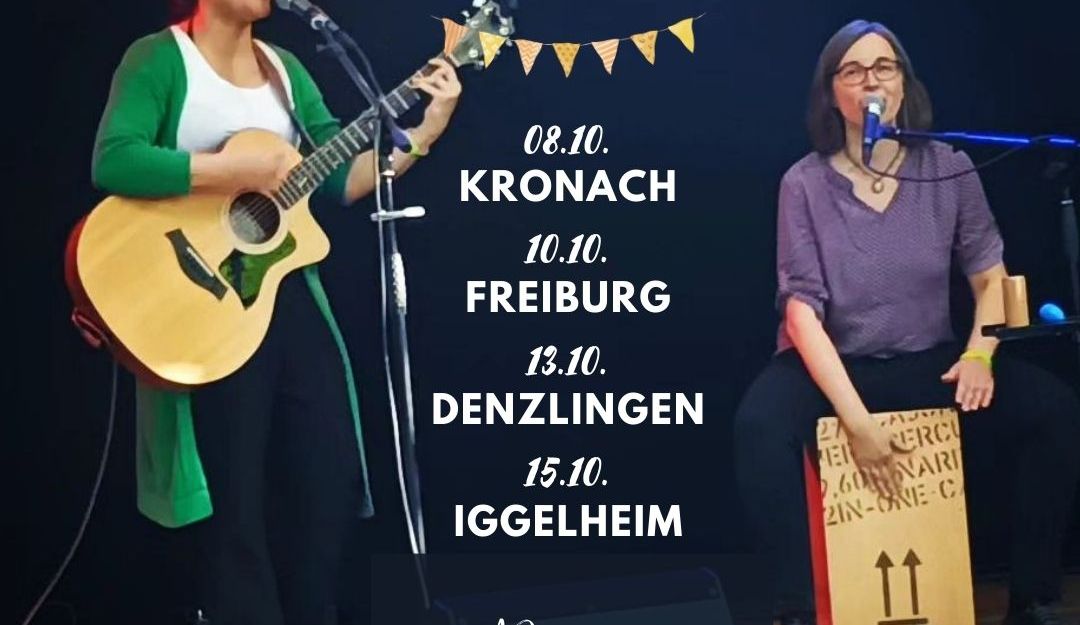 Es sind zwei fröhliche Musikerinnen auf einer Bühne zu sehen. Eine spielt Gitarre, die andere sitzt auf einer Cajon und trommelt. Es sind Ines Herrmann und Zannahh. In der Mitte des Bildes steht eine Überschrift, die mit einer kleinen Wimpelkette unterstrichen ist. Die Überschrift lautet "Live Music". Darunter stehen die vier Konzerttermine der beiden Künstlerinnen: 08.10. in Kronach, 10.10. in Freiburg, 13.10. in Denzlingen und 15.10. in Iggelheim. Mehr Informationen gibt es auf inesherrmann.eu/tour. Das steht ganz unten auf dem Bild mit drauf.