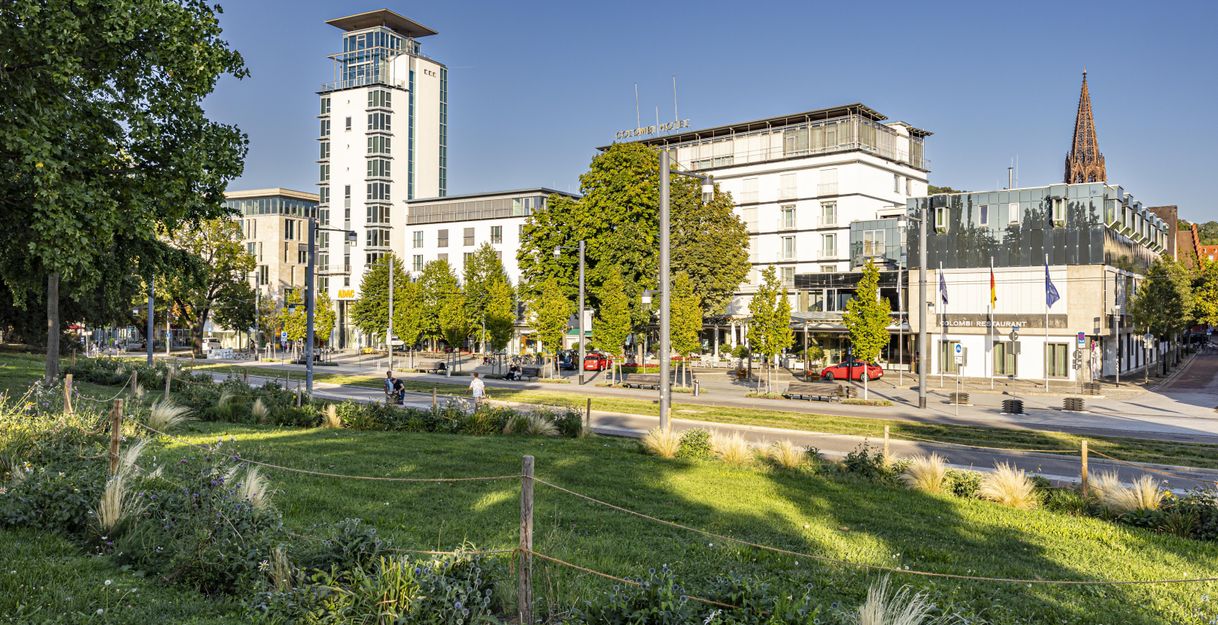 Stadtansicht Colombi Hotel in Freiburg und grünem Park im Vordergrund.