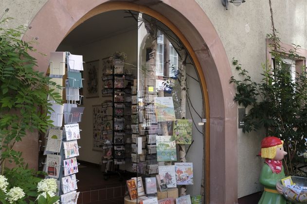 Eingang der Buchhandlung Fundevogel mit Büchern und Karten im Schaufenster.