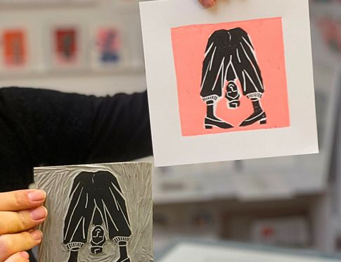Ein im Workshop entstandener fertiger Linoldruck und die dazu gehörende Druckplatte werden in die Kamera gehalten