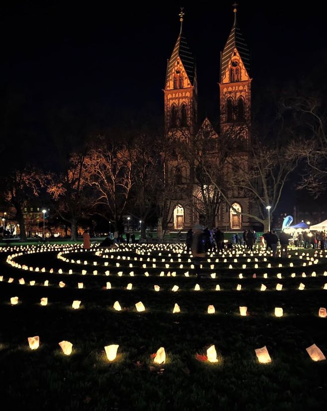 Der Stühlinger Kirchplatz aus Froschpespektive erleuchtet mit einem Labyrinth aus Teelichtern