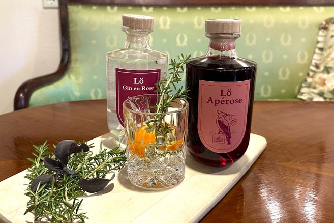 Gin-Flasche, Gin-Glas, Gewürzzweig, auf glänzenden Holztisch stehend
