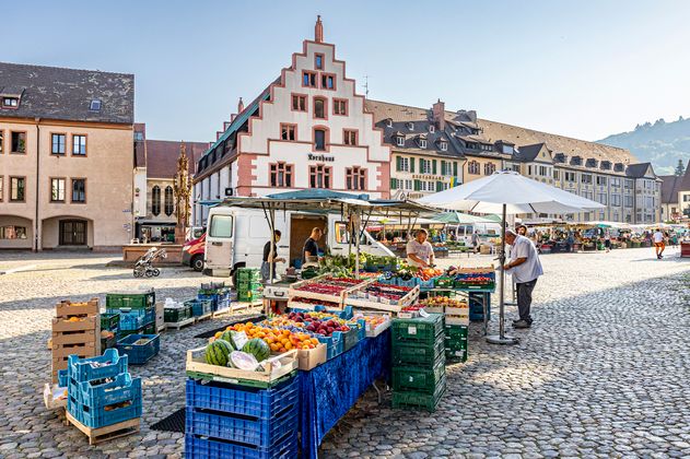 Stand auf dem Münstermarkt mit Obst und Gemüse und im Hintergrund das Kornhaus 