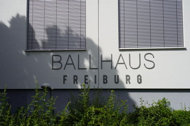 Fassade des Ballhaus Freiburg mit Schriftzug und Fenstern mit Jalousien.