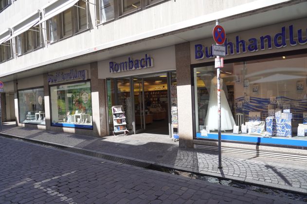 Eingang der Buchhandlung Rombach mit Schaufenstern und Büchern.